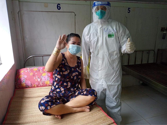 Điều dưỡng Nguyễn Văn Mạnh bên cạnh một bệnh nhân COVID-19 có chuyển biến tốt